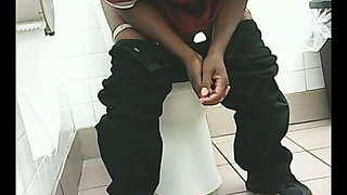 Black woman in black jeans urinating in the public toilet room