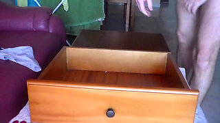 John is pissing into the bookcase drawer