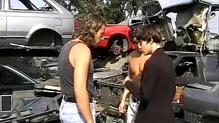 Short-haired German babe getting fucked by two hard cocks at the car waste