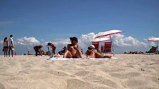 Sensuous babes in sexy bikinis sunbathing on the beach