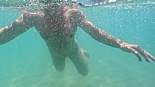 Curvy naked girl swims underwater with anal plug