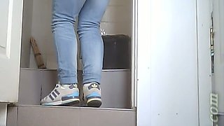White chick in blue jeans and coat pisses in the toilet