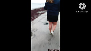 Hot wife walking on the beach with her husband without interiors.