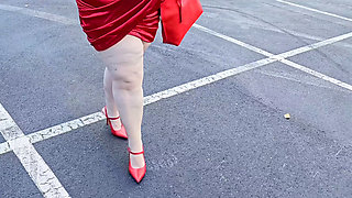 Beautiful woman walking outdoors in public parking lot showing off for strangers