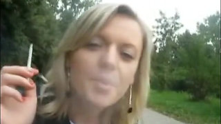 Blonde beauty smoking a cigarette outdoors