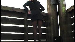 Horny girl sticks  a long dildo into her shaved pussy outdoors